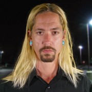 Man with long blond hair and brown mustache and goatee